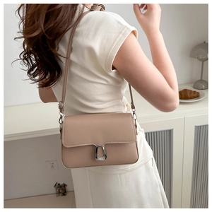 Detail view of milk tea colored square bag with silver metallic buckle on PU leather