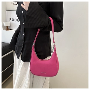 Detail view of fuchsia hobo bag with litchi texture and elegant metal chain strap