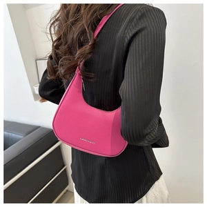 Detail of rose pink hobo bag featuring litchi grain texture and silver fashion logo