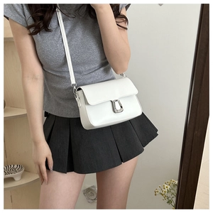 Mirror selfie showing white crossbody bag with silver horseshoe buckle and adjustable strap