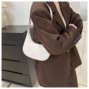 Detail of white moon-shaped hobo bag in lychee pattern leather with minimalist strap