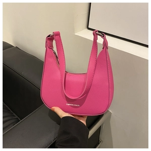 Detailed shot of pink faux leather underarm bag with lychee texture and metal rings