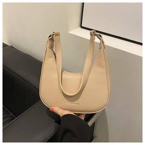 Detail showing high-quality pebbled leather texture and silver fashion logo on hobo bag