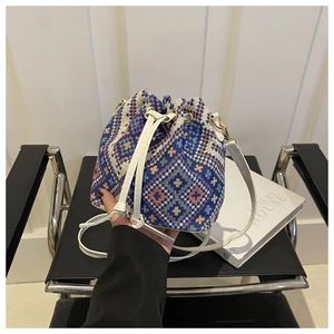 Detailed shot of ethnic woven bucket bag with vibrant geometric patterns and drawstring