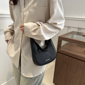 Chic black pebbled leather crescent underarm bag with delicate gold chain strap