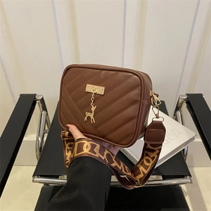 Sac à bandoulière matelassé marron avec pendentif cerf doré et sangle à motifs