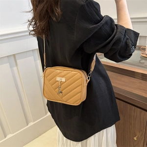 Minimalist V-quilted brown crossbody bag with gold deer charm and sleek camera bag shape