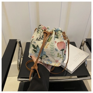 Detail of ethnic floral jacquard bucket bag with drawstring and brown leather strap