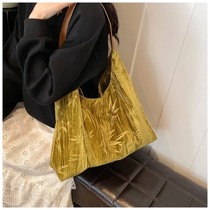 Close-up of bamboo leaf pattern velvet tote bag with brown leather shoulder strap
