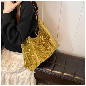 Detailed close-up of golden velvet fabric with elegant bamboo leaf jacquard patterns