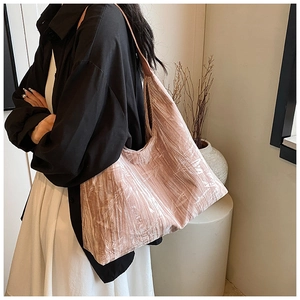 Detail of pink pleated velvet shoulder bag showing textured fabric and elegant draping