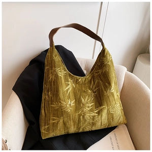 Close-up of olive green corduroy tote bag with bamboo patterns and leather handles