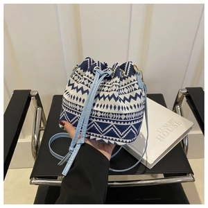 Detailed view of woven bucket bag with blue geometric patterns and drawstring closure