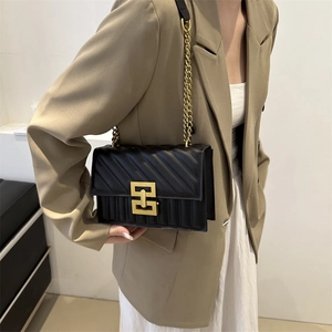 Classic black quilted leather crossbody bag with gold chain strap and geometric buckle