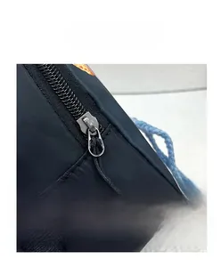 Detail of durable metal zipper closure with non-slip pull tab on black nylon belt bag
