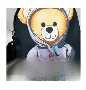 Close-up of cute teddy bear patch with real blue drawstrings on black canvas waist bag