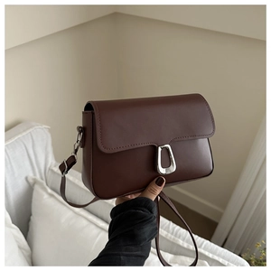 Detail of dark brown matte leather crossbody bag with silver square metal buckle closure