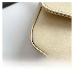 Macro shot of cream white leather texture and precise stitching on the shoulder bag