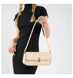 Detailed macro view of the cream-white faux leather baguette bag with a gold metal buckle