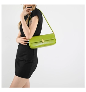 Close-up of bright green rectangular baguette bag with a golden oval metal magnetic clasp