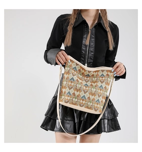 Détail du sac fourre-tout tissé aux motifs géométriques colorés et anses en cuir