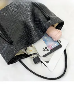 Detail view of large woven tote bag interior showing capacity for tablet and daily items