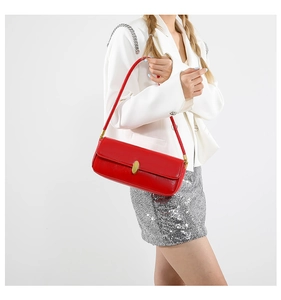 Model wearing a red patent leather baguette bag with golden buckle and sequined dress