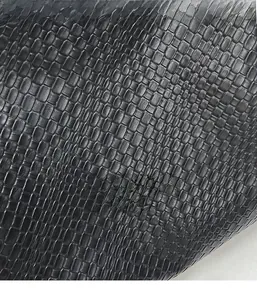 Macro shot of black woven leather texture on a casual tote bag with detailed checkered pattern