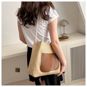 Détail du sac cabas en paille tissée avec poche en cuir brun et poignée en corde blanche