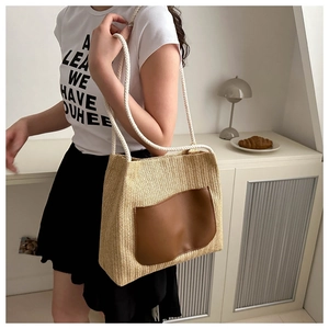 Détail du sac cabas en paille tissée avec poche en cuir marron et anse en corde