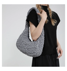 Dettaglio del tessuto popcorn grigio su una borsa a tracolla hobo pieghettata con cerniera