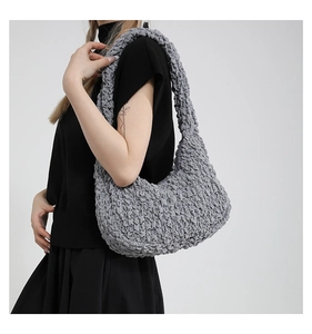 Dettaglio della borsa tote grigio chiaro con trama a popcorn e design minimalista