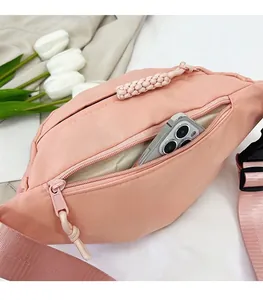 Détail du sac banane rose en nylon avec tirette tissée et compartiment interne spacieux
