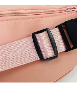 Détail du sac de poitrine en nylon rose avec boucle en plastique noir et sangle réglable