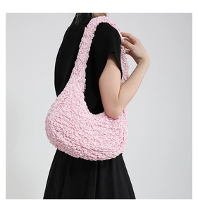 Dettaglio del tessuto rosa con trama a popcorn su una borsa a tracolla elegante