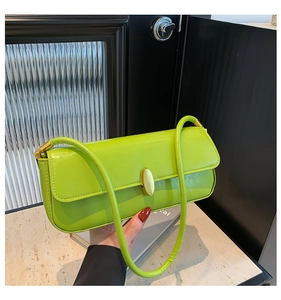 Detailed close-up of a bright green baguette bag with a golden oval twist lock