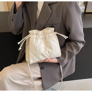 Detail of white quilted drawstring bucket bag with elegant diamond lattice pattern