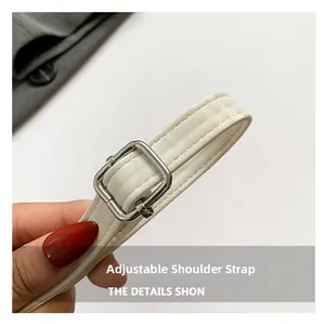 Detail of adjustable off-white synthetic leather shoulder strap with silver metal buckle