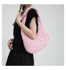 Dettaglio della borsa a pieghe rosa che mostra la texture elastica a bolle e il colore tenue