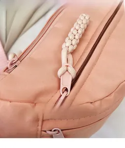 Détail du sac bandoulière rose corail avec fermeture éclair en métal et cordon tissé