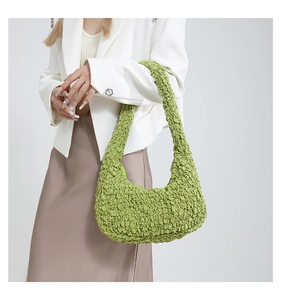 Borsa a spalla verde neon con texture a pieghe indossata su un outfit minimalista