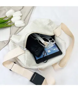 Macro shot of large white corduroy bucket bag interior holding a tablet and umbrella