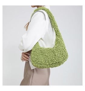 Dettaglio della borsa hobo verde con texture a bolle e catena metallica d'argento