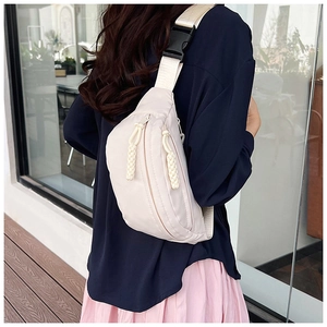 Détail du sac de poitrine en nylon blanc crème avec cordons de fermeture tissés