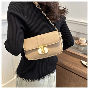 Close-up of beige square leather bag featuring a gold T-bar lock and chain strap detail