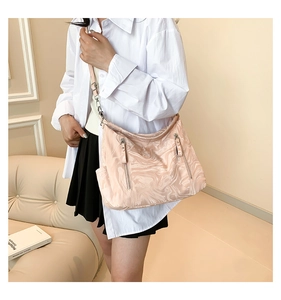 Detail of light pink marble pattern shoulder bag with silver zippers and half-moon design