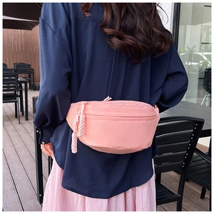 Vue arrière du modèle portant un sac banane en nylon rose imperméable au café