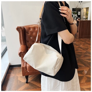 Detailed texture of white corduroy shoulder bag with broad strap on casual outfit
