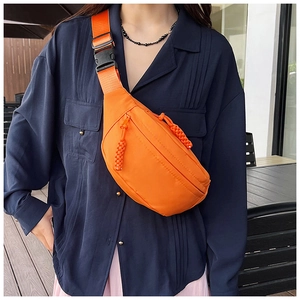 Détail du sac banane orange avec sangle réglable et tirettes de fermeture tissées