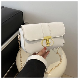Detail of white leather shoulder bag featuring a prominent gold T-shaped metal clasp buckle